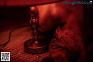 A woman sitting on the floor playing a tabla.