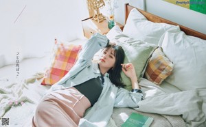 A woman in a white shirt and white pants is posing for a magazine.