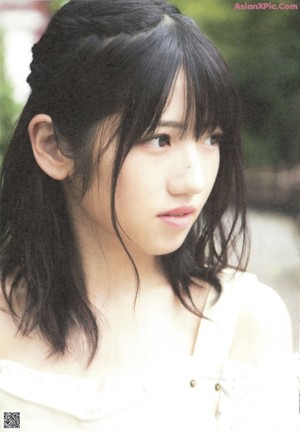 A young woman with long black hair and bangs smiles at the camera.