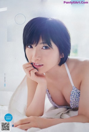 A woman in a black bikini posing for a magazine.