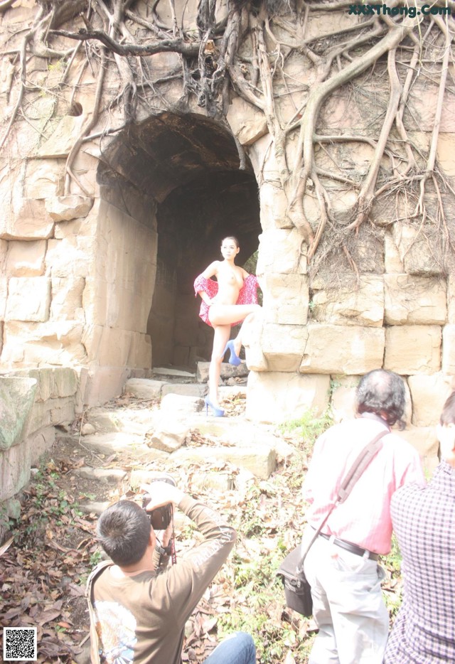 A group of people taking pictures of a woman in a tunnel.